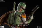 Rear three-quarter view of the Boba Fett sixth-scale figure showing the green jetpack, brown cape, helmet rangefinder, and blaster rifle