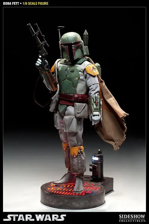 Full-body Boba Fett sixth-scale figure standing on a display base with a blaster rifle, jetpack, brown cape, and weathered green armor