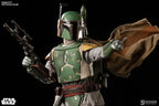Boba Fett sixth-scale figure posing with a blaster rifle and raised arm, wearing weathered green armor, yellow shoulder plates, and a flowing brown cape